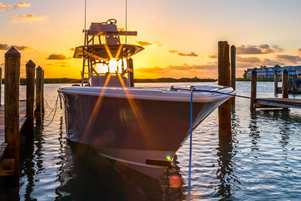 A boat is docked in the water at sunset.